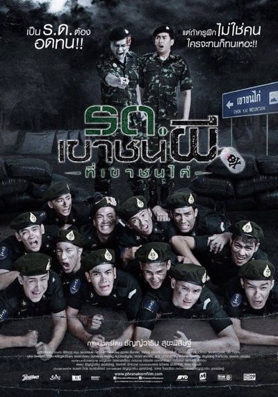 The bottom half of the poster features twelve people in military uniforms who lie stacked on top of each other with various comical facial expressions implying discomfort. They all have light skin and dirt on their faces. Just above the stack of twelve people is the title of the film, and just above that two more people in military outfits with stand above the pile. The one on the left is a zombie with grey skin and open lesions, and points towards the pile of twelve with their mouth open mid-scream. The one on the right has light skin and stares at the zombie with a shocked and concerned expression.