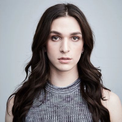 Eve Lindley with slightly parted lips and a neutral expression. Eve is Cuban/American and has long dark wavy hair and light skin. She wears a sleeveless top and a couple stud earrings.