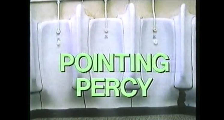 A shot of white urinals in a row with the film title "Pointing Percy" in large, faintly yellow-green capital letters.The room where the urinals are appears to be dingy with patchy, weathered walls and flooring.